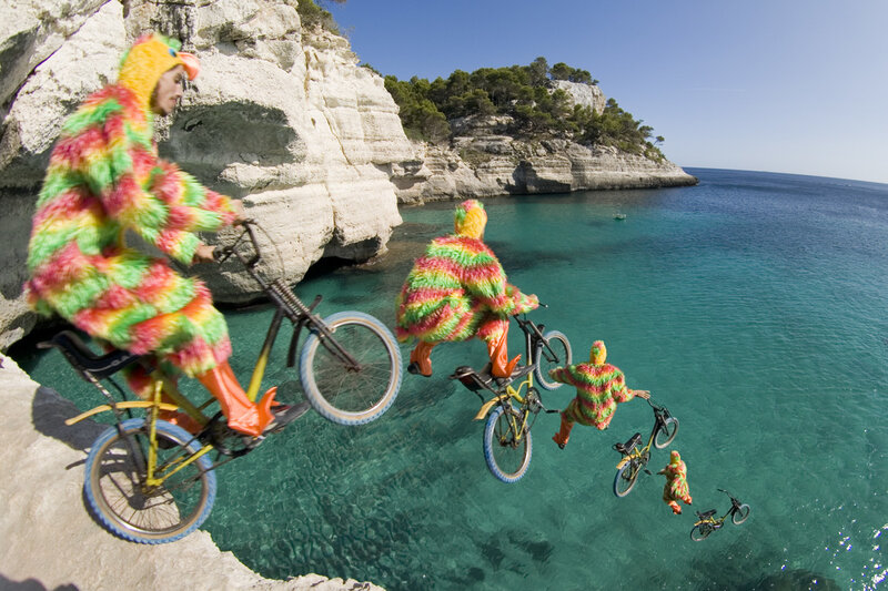 People in costumes on bikes by sea