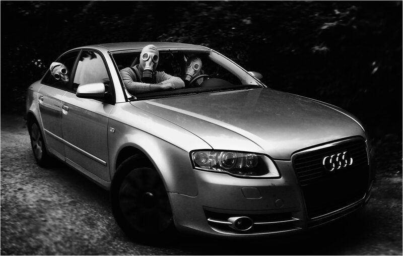 People in gas masks in a car