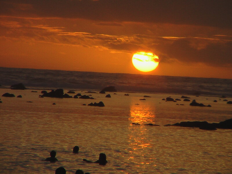 People in Ocean at Sunset — Orange, Dramatic