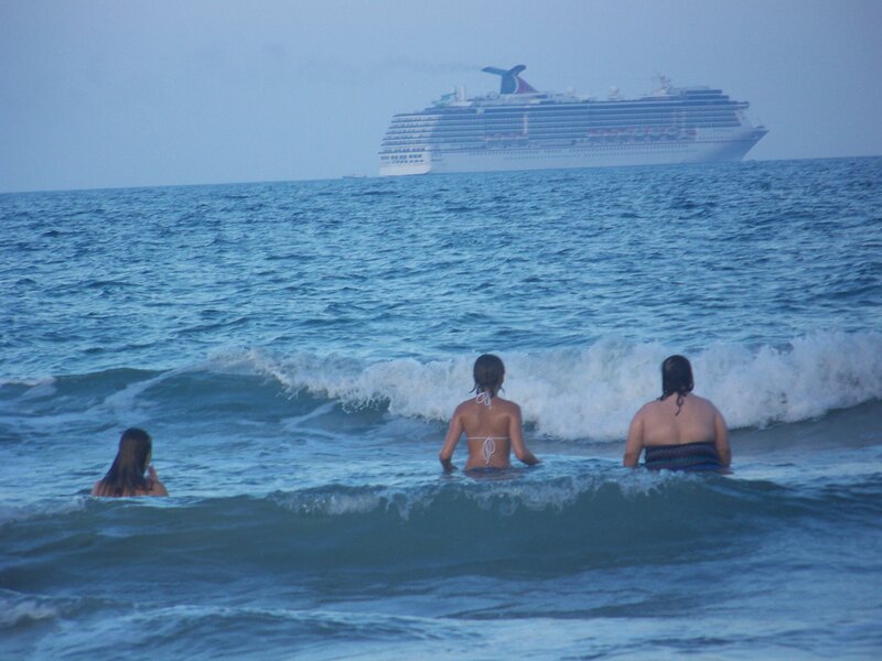 People in ocean with cruise ship