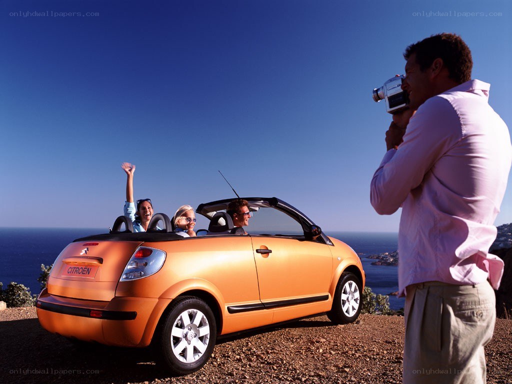 People in orange convertible car