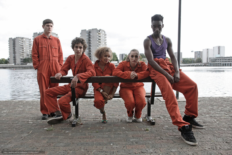 People in orange jumpsuits by water