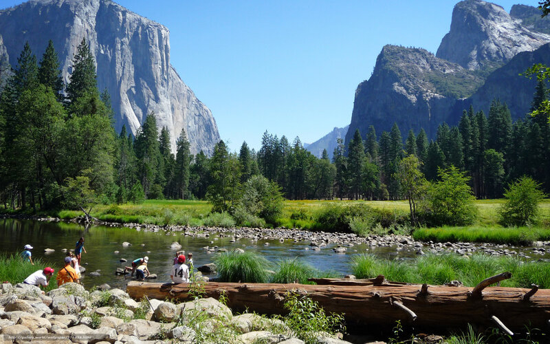People in River Near Mountains