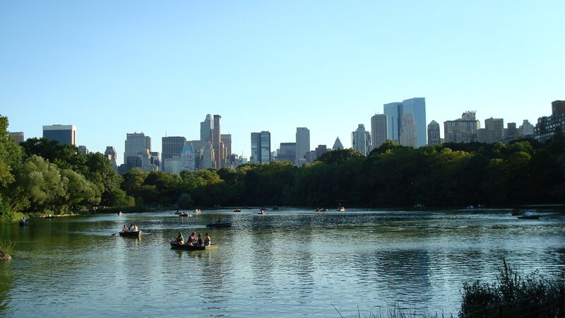 People in Rowboats on Lake