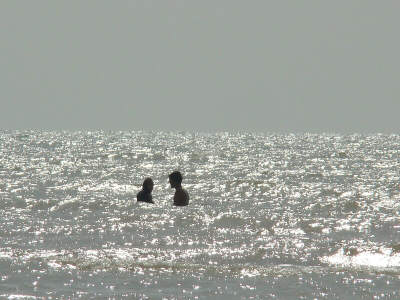 People in the ocean at sunset