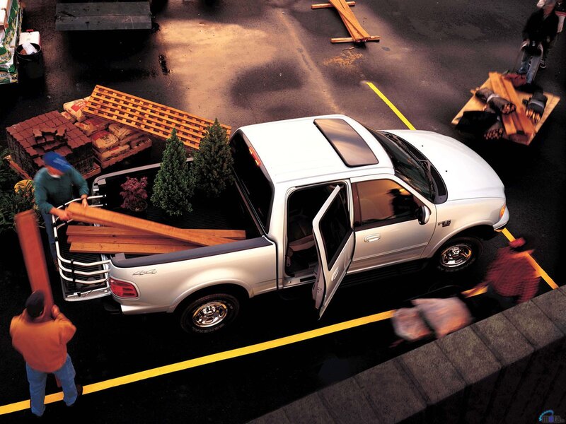 People loading wood into a pickup truck