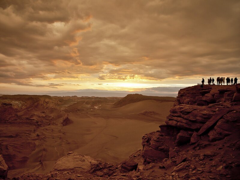 People on a cliff at sunset