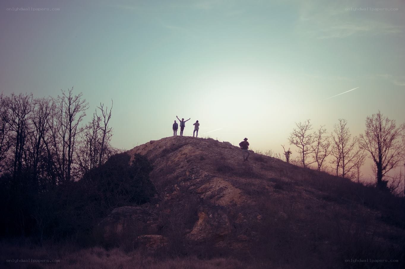 People on a hill at sunset