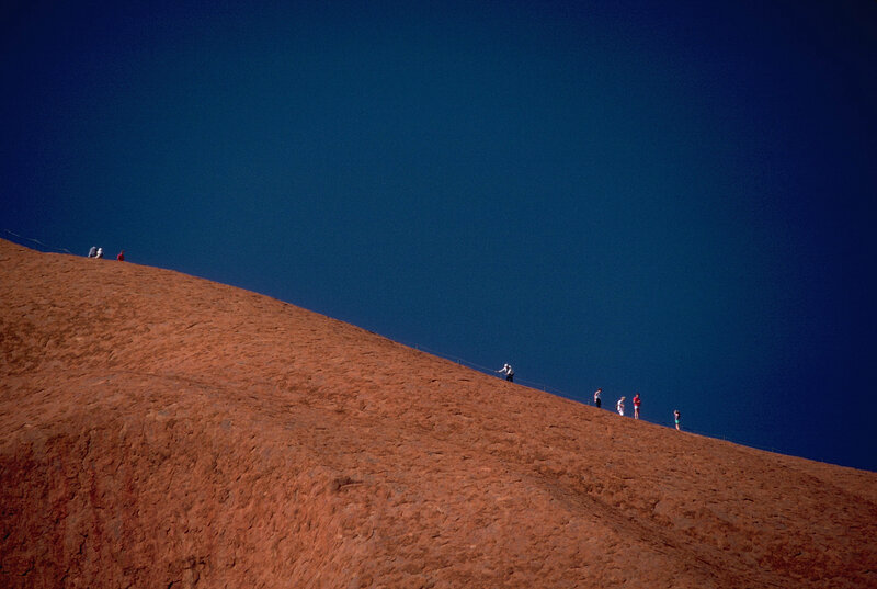 People on a red rock hill