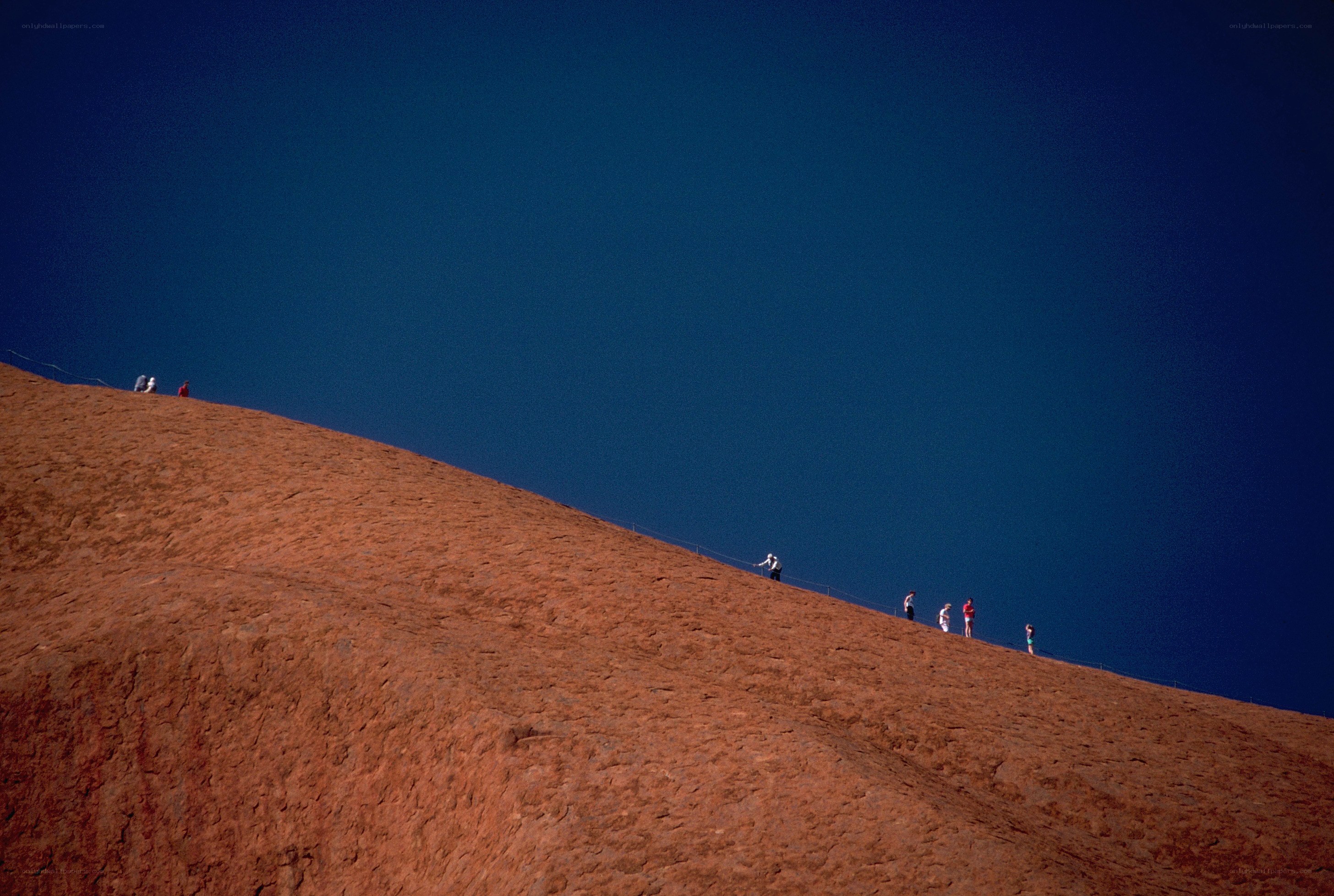 People on a red rock hill