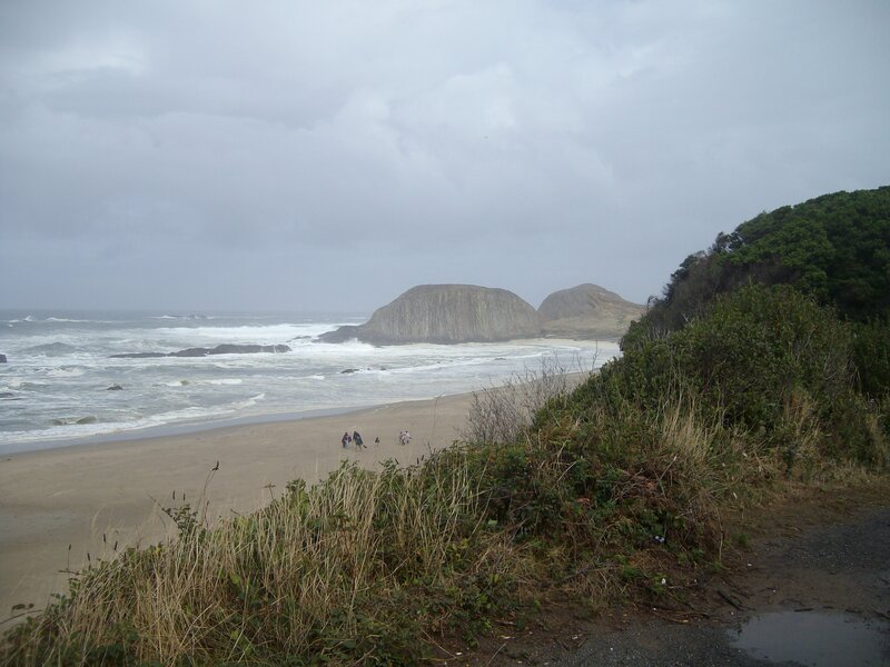 People on Beach Near Rocks