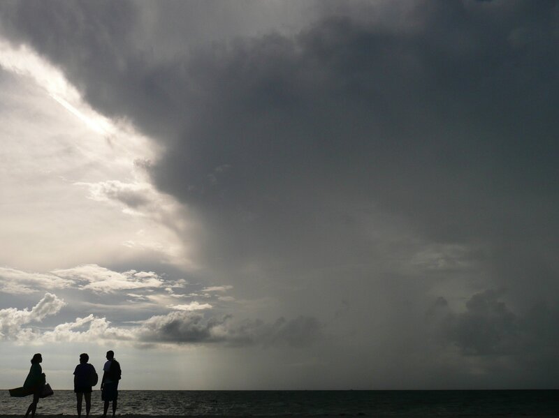 People on beach under stormy sky