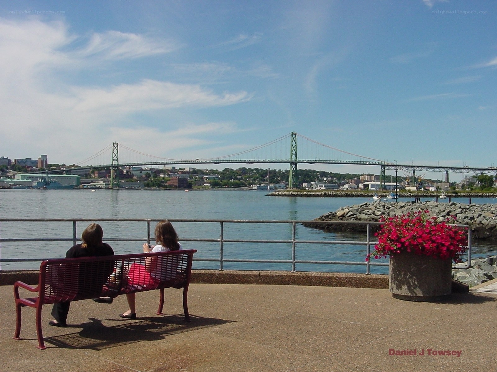 People on bench by bridge