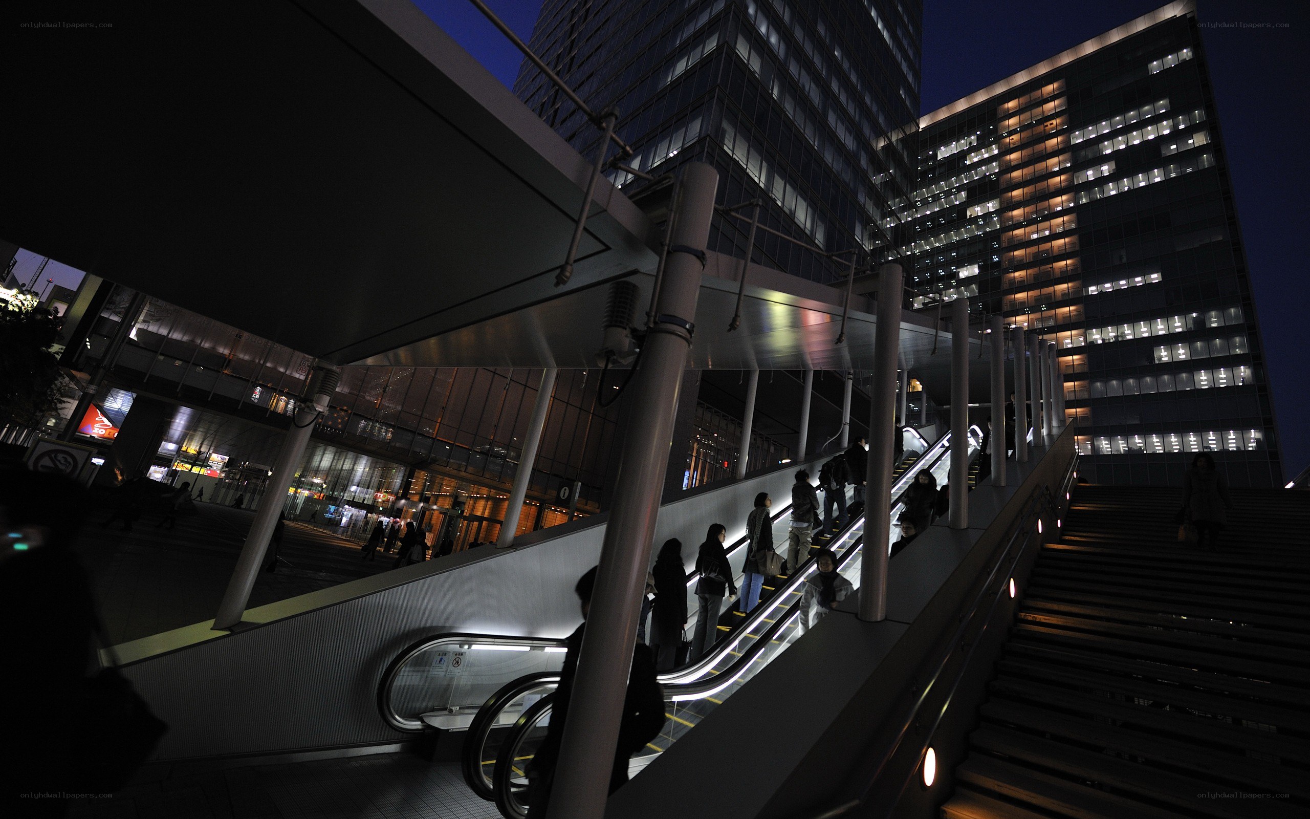 People on escalator at night