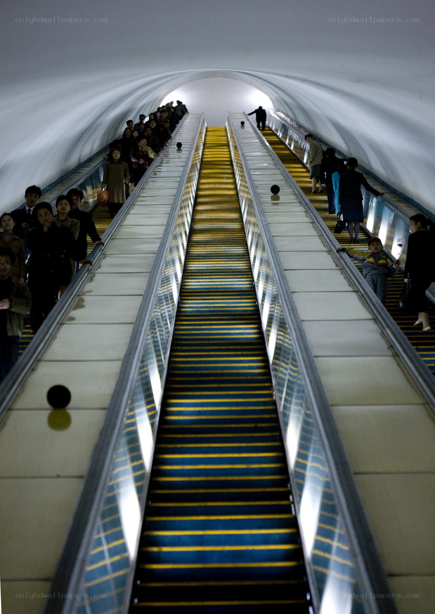 People on escalators in a tunnel