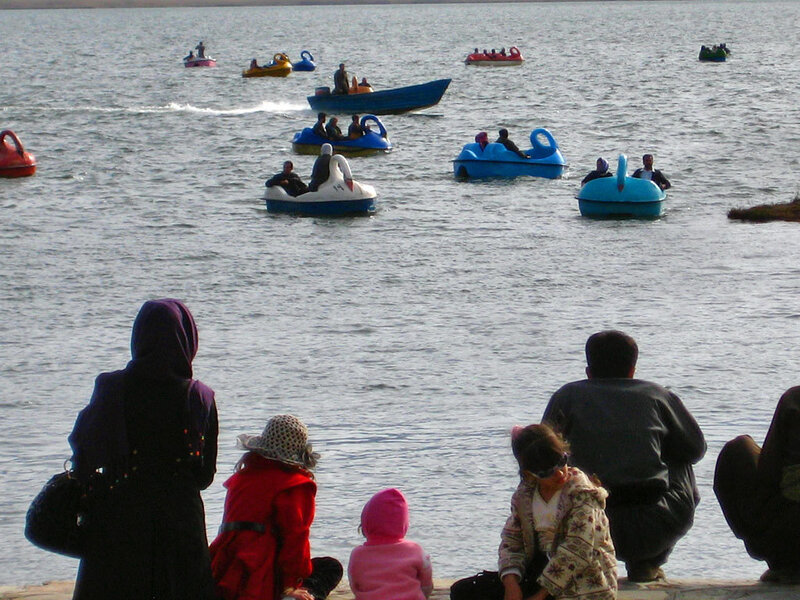 People on paddle boats at a lake