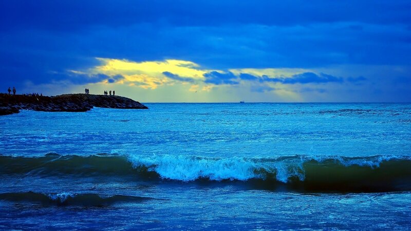 People on Rocky Jetty — Blue