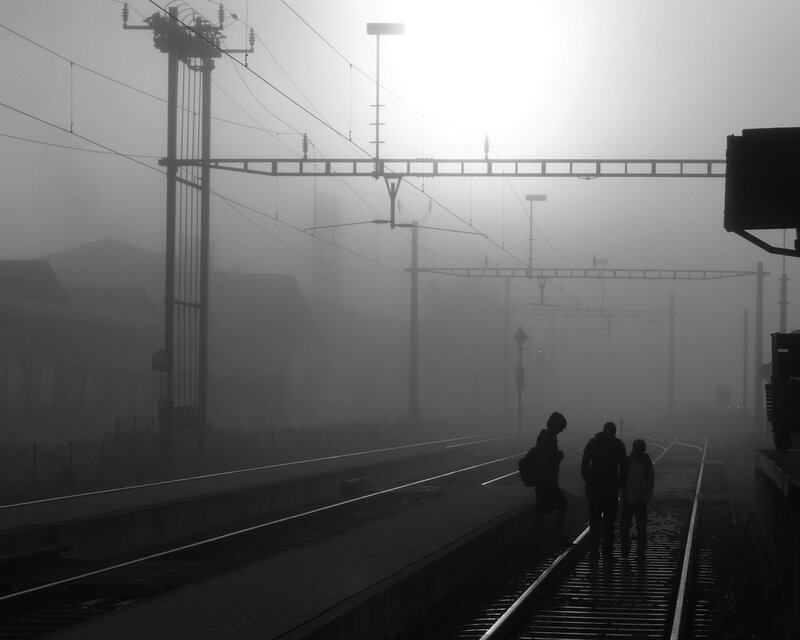 People on train tracks in fog