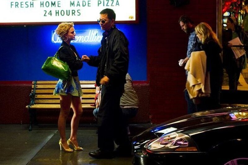 People outside a pizza shop at night