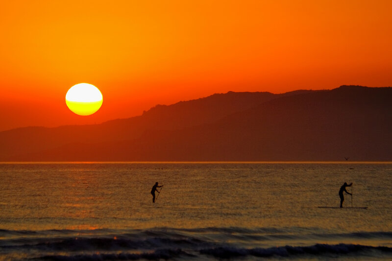 People Paddleboarding at Sunset