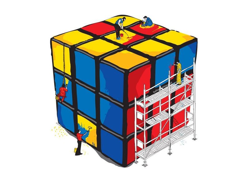 People painting a giant Rubik's cube