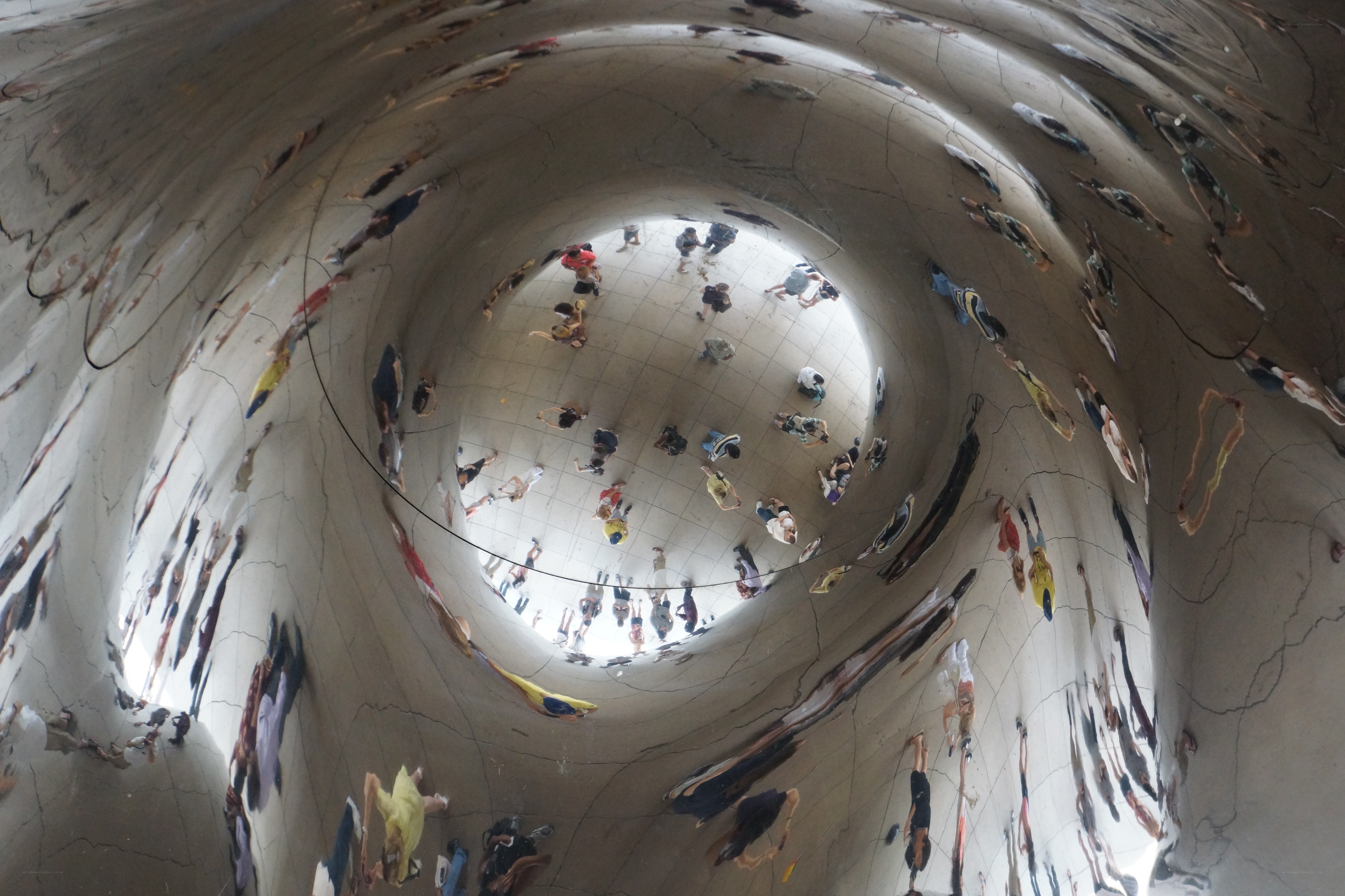 People reflected in a sculpture