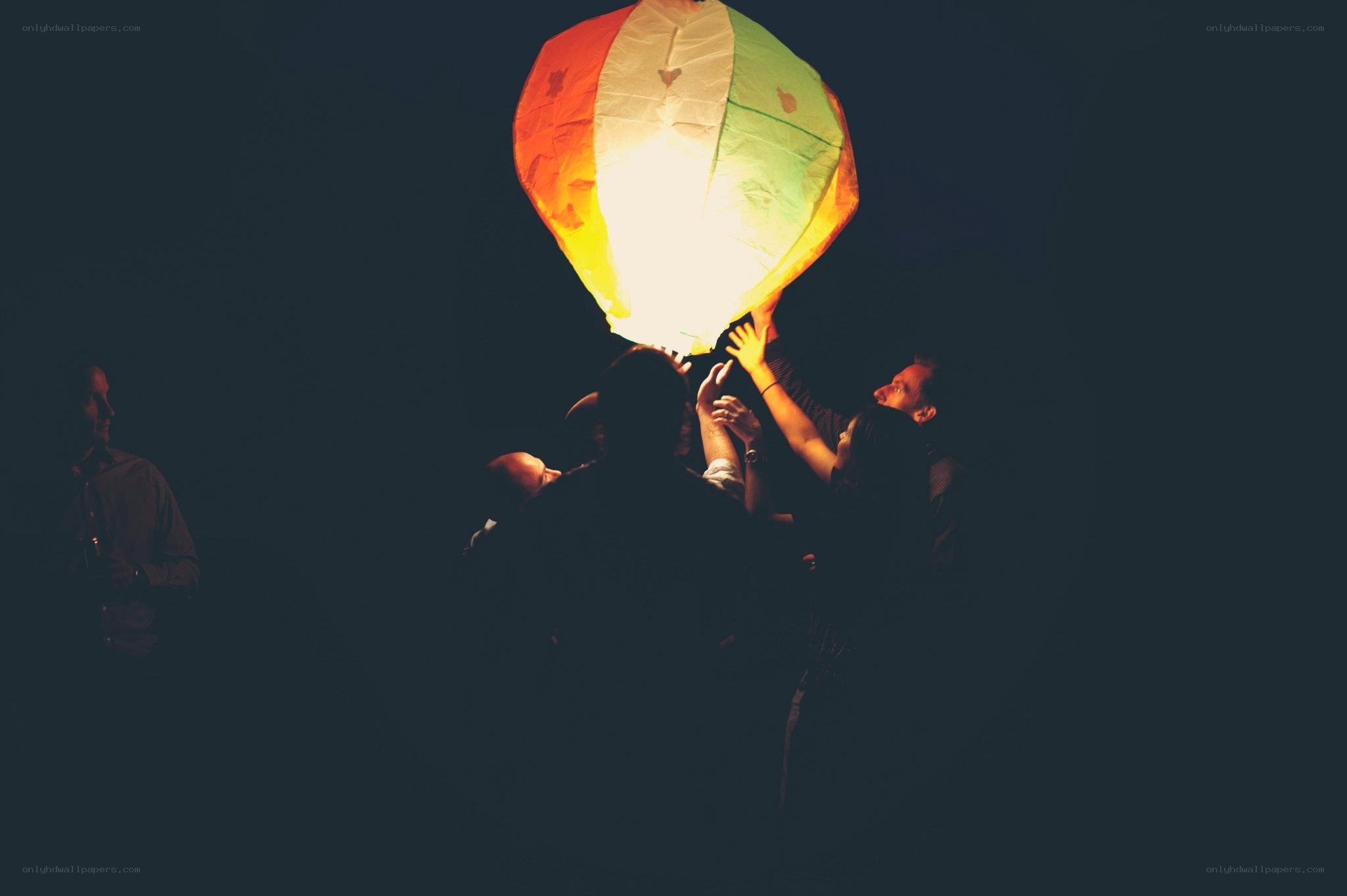 People releasing a sky lantern