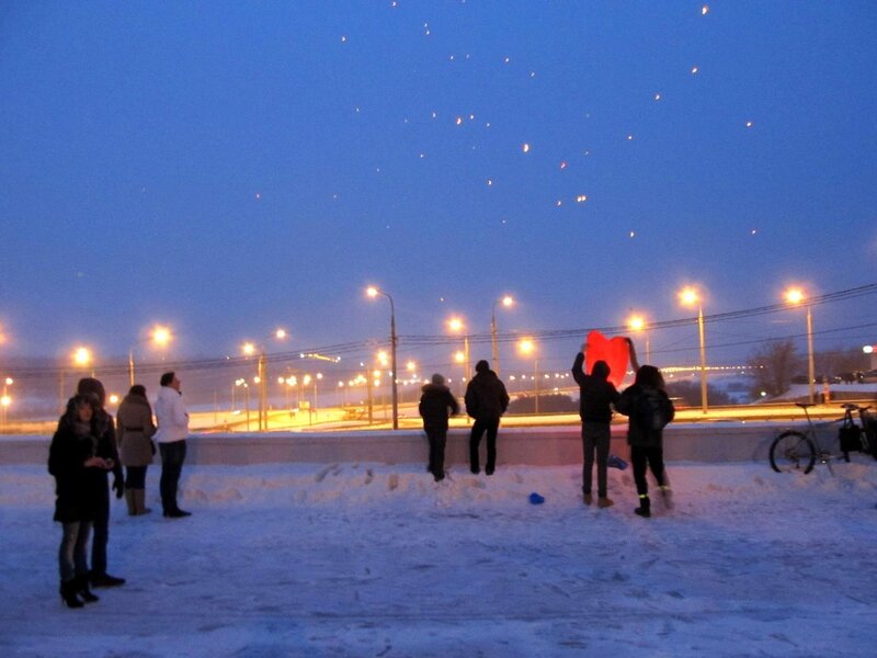 People releasing lanterns at dusk