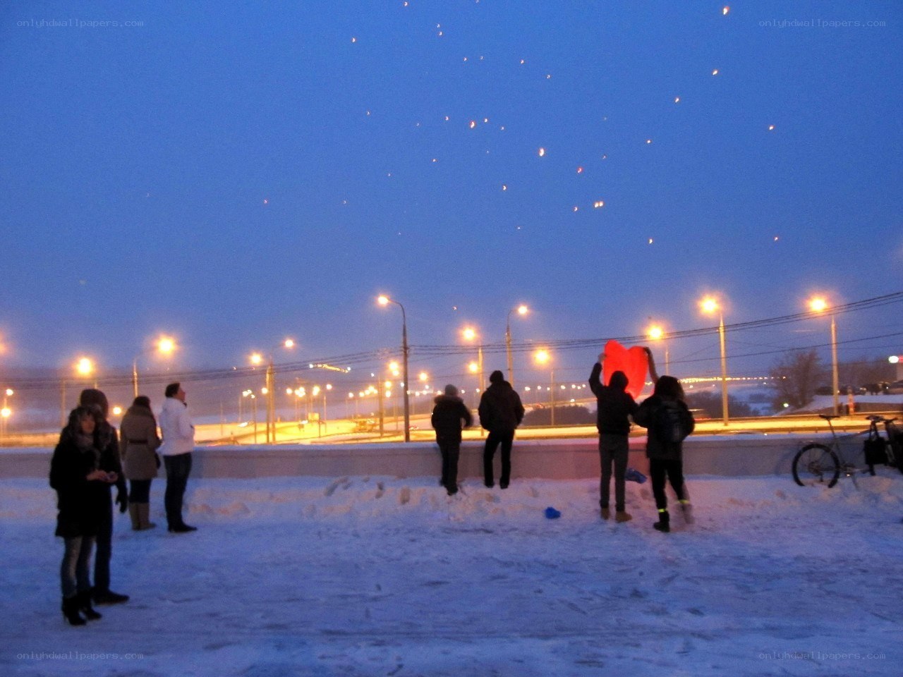 People releasing lanterns at dusk