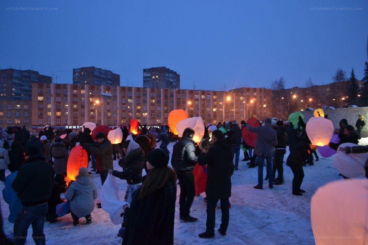 People releasing lanterns at night