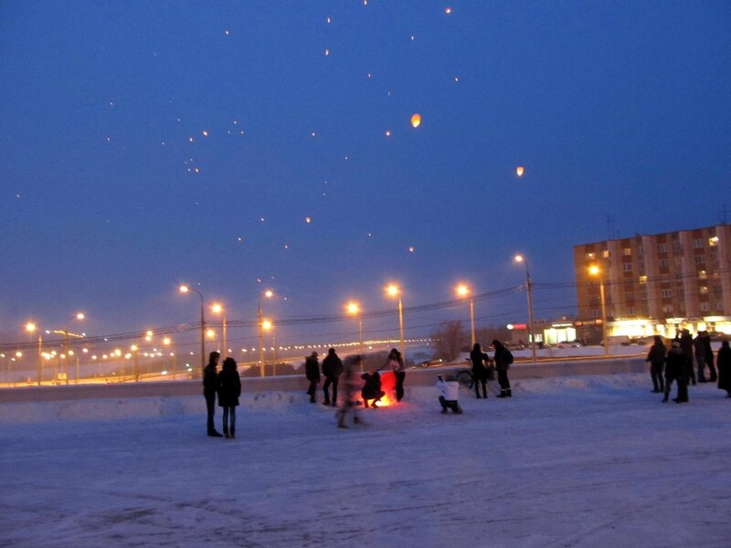 People releasing sky lanterns at night
