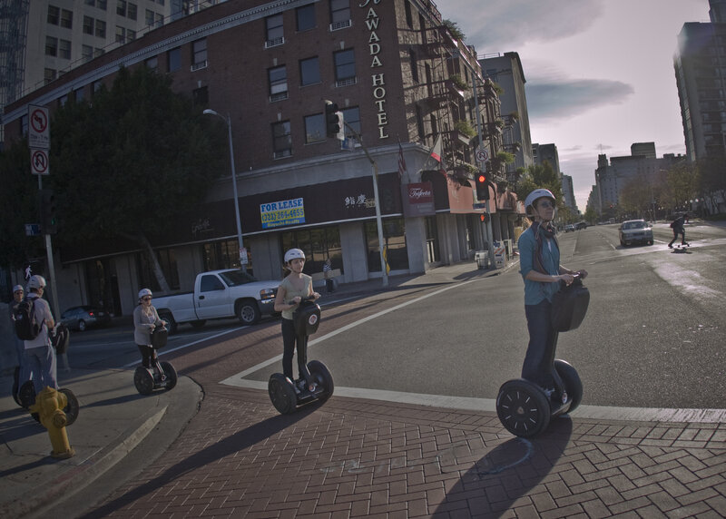People riding segways on city street