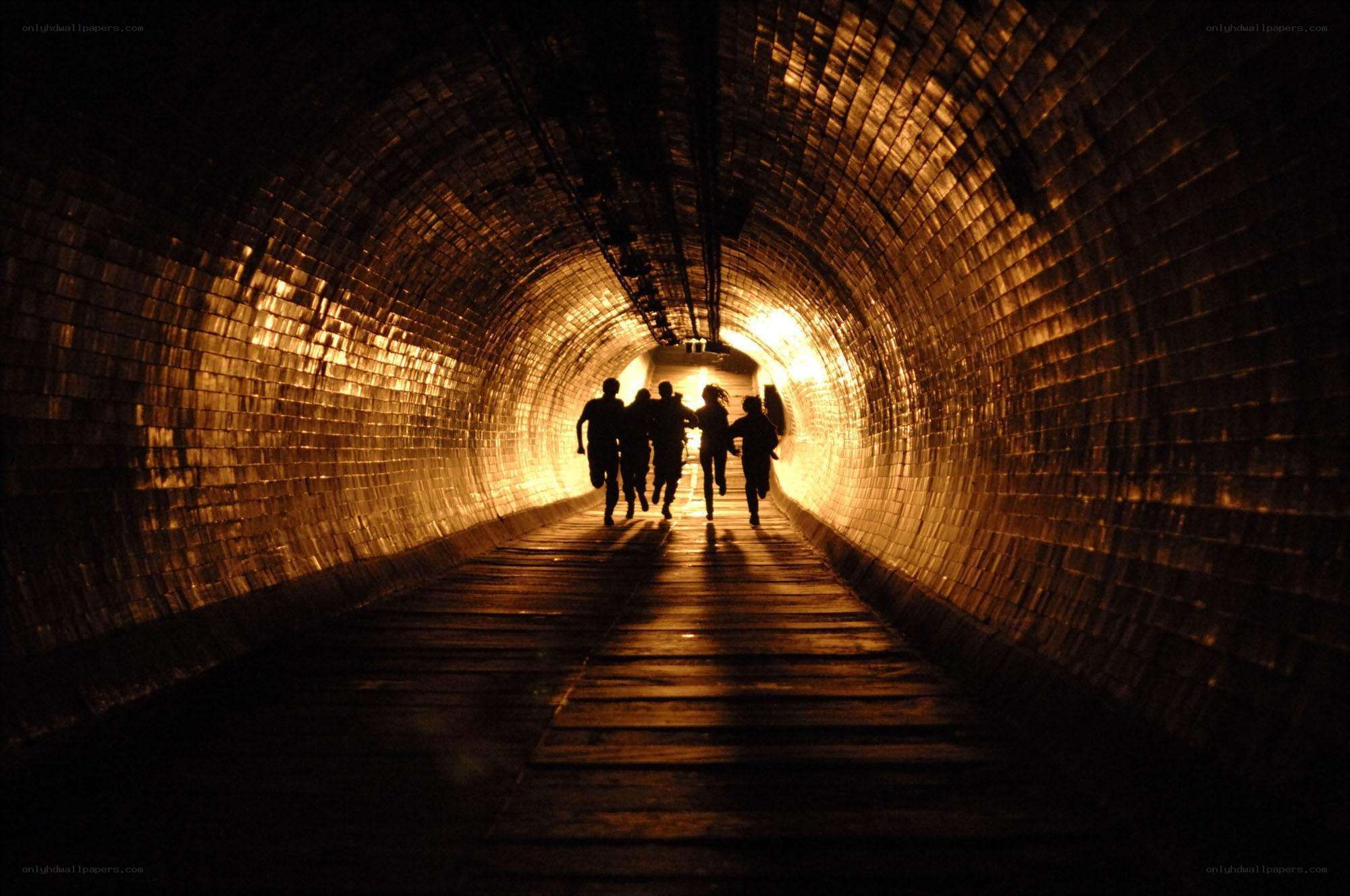 People running through a tunnel