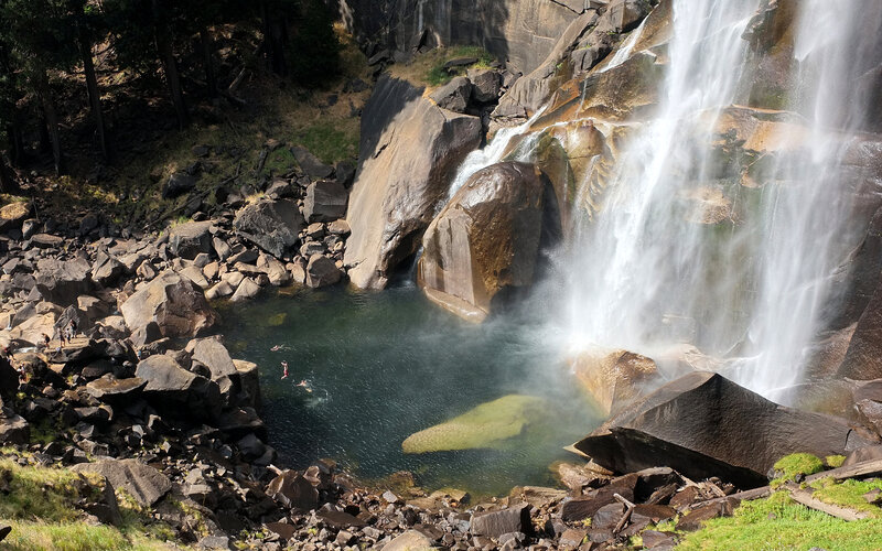People Swimming at Waterfall