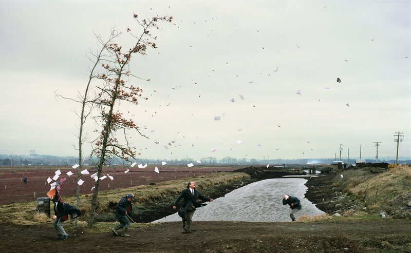 People throwing papers in a field