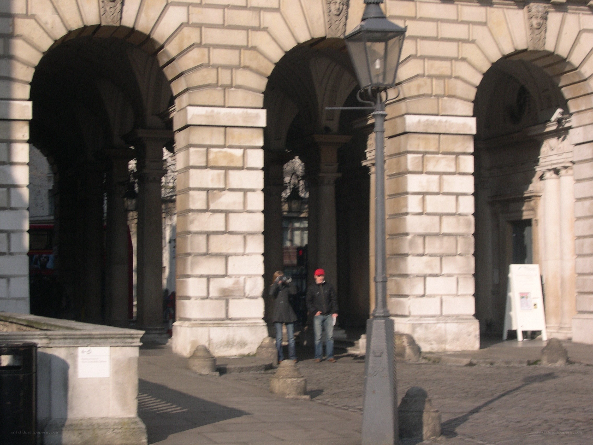 People under stone arches