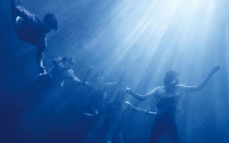 people underwater with light rays