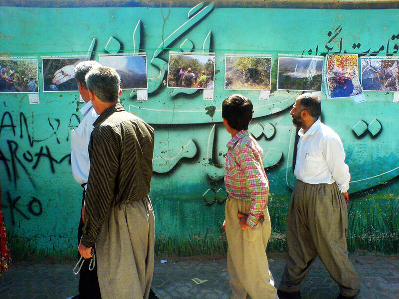People viewing photos on a wall