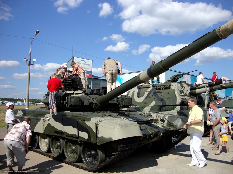 People viewing tanks at an outdoor event