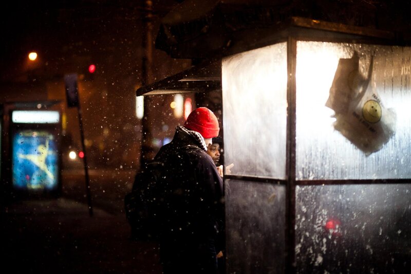 People waiting at a bus stop in snow