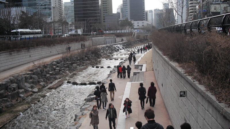People walking along a river in Seoul