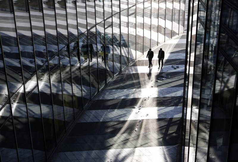 People walking in a glass corridor