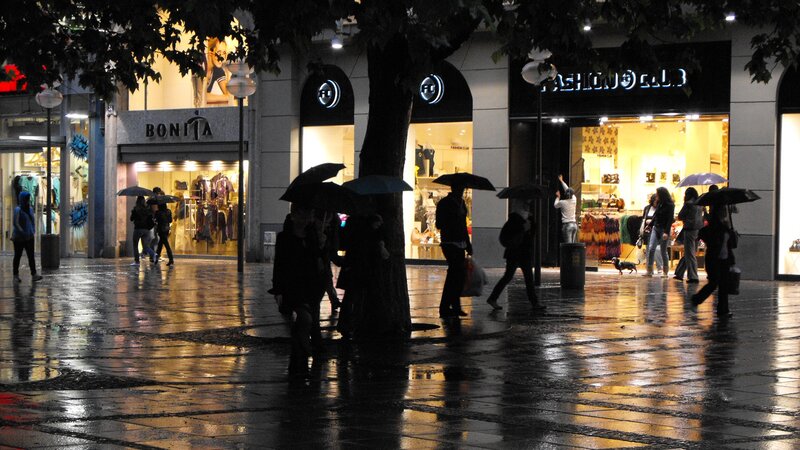 People walking in rain at night
