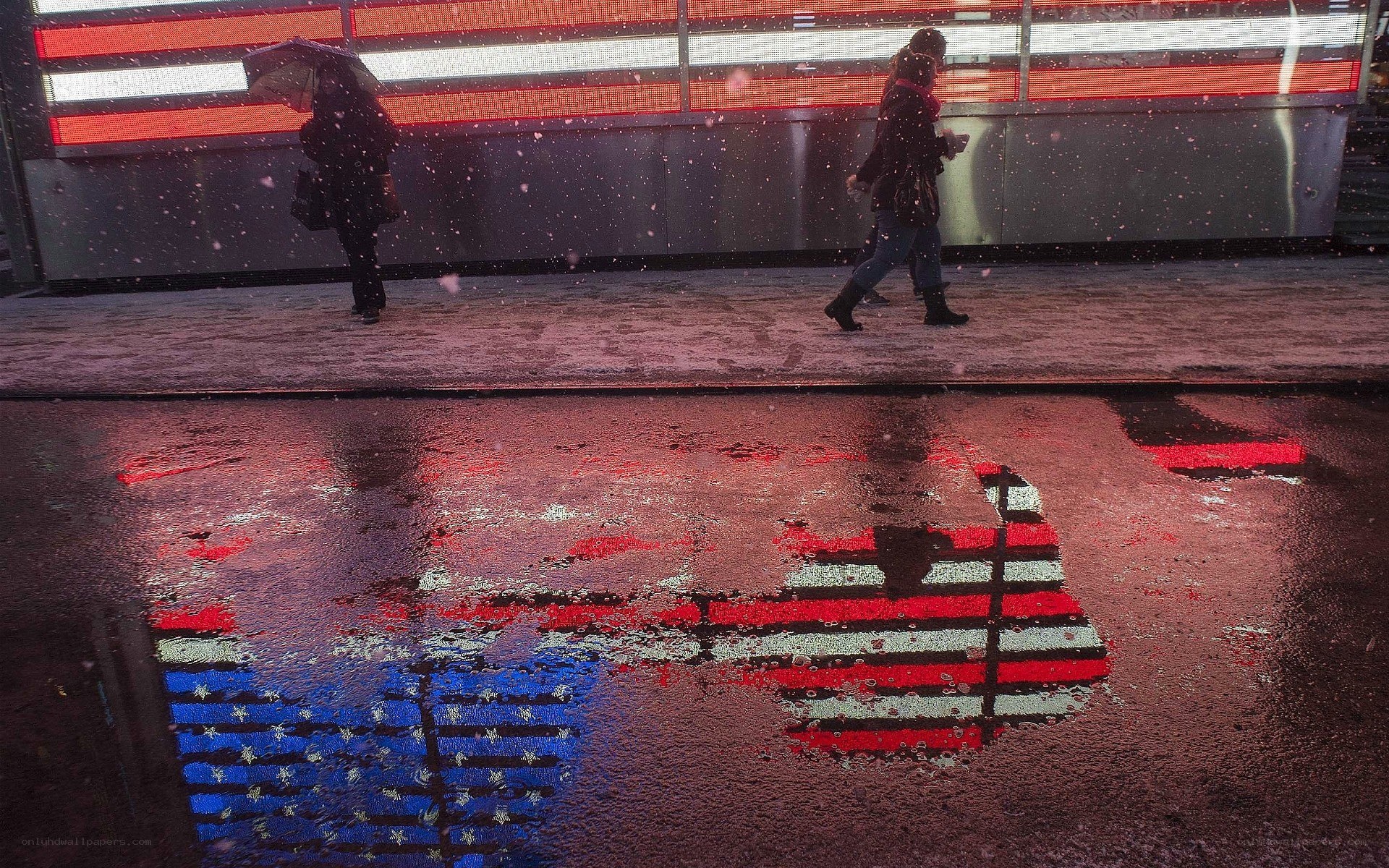 People walking in snow with flag reflection