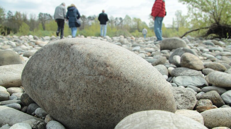 People walking on a rocky riverbank