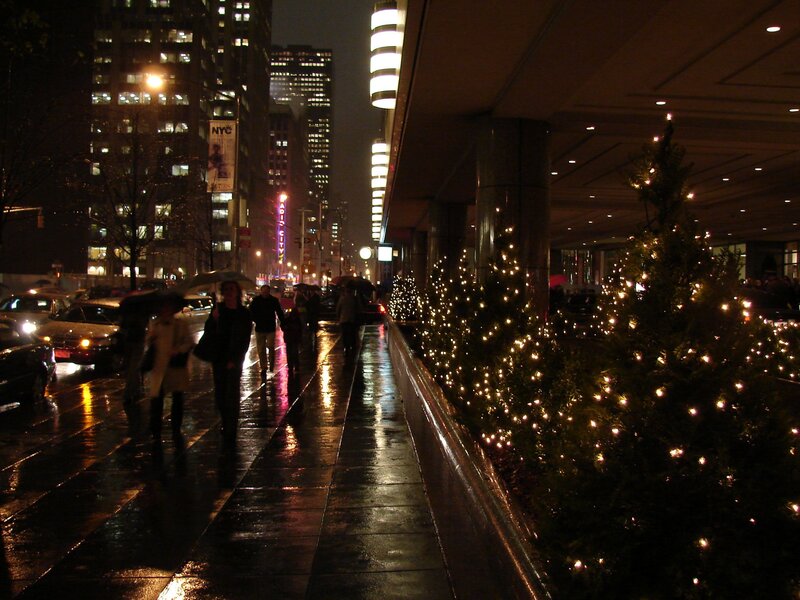 People walking on wet sidewalk at night