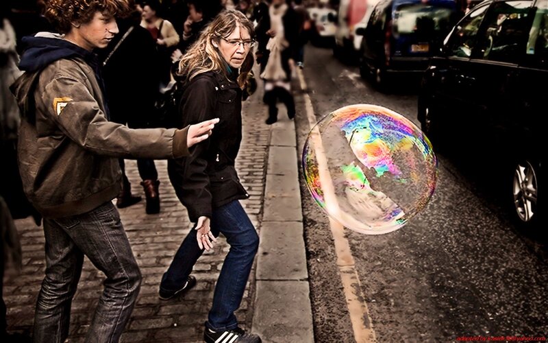 People walking with a large soap bubble