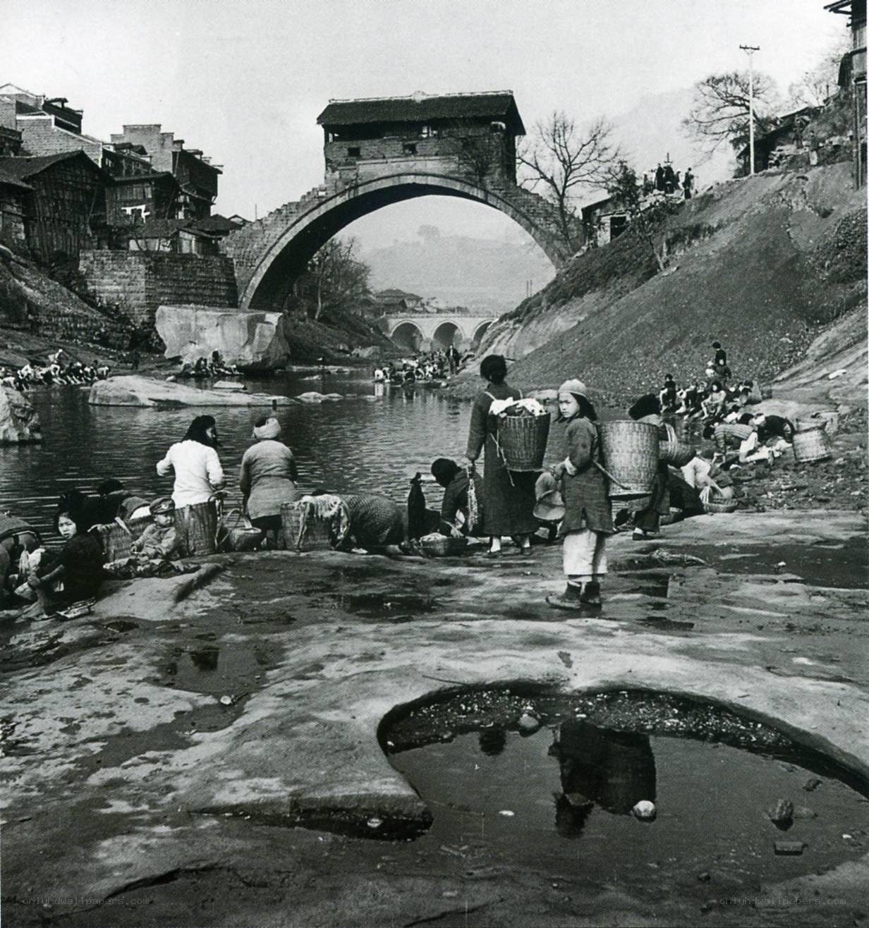 People washing clothes by a river