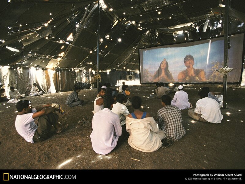 People watching film in tent