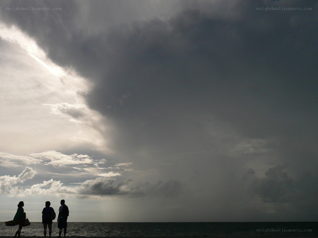 People watching storm at beach
